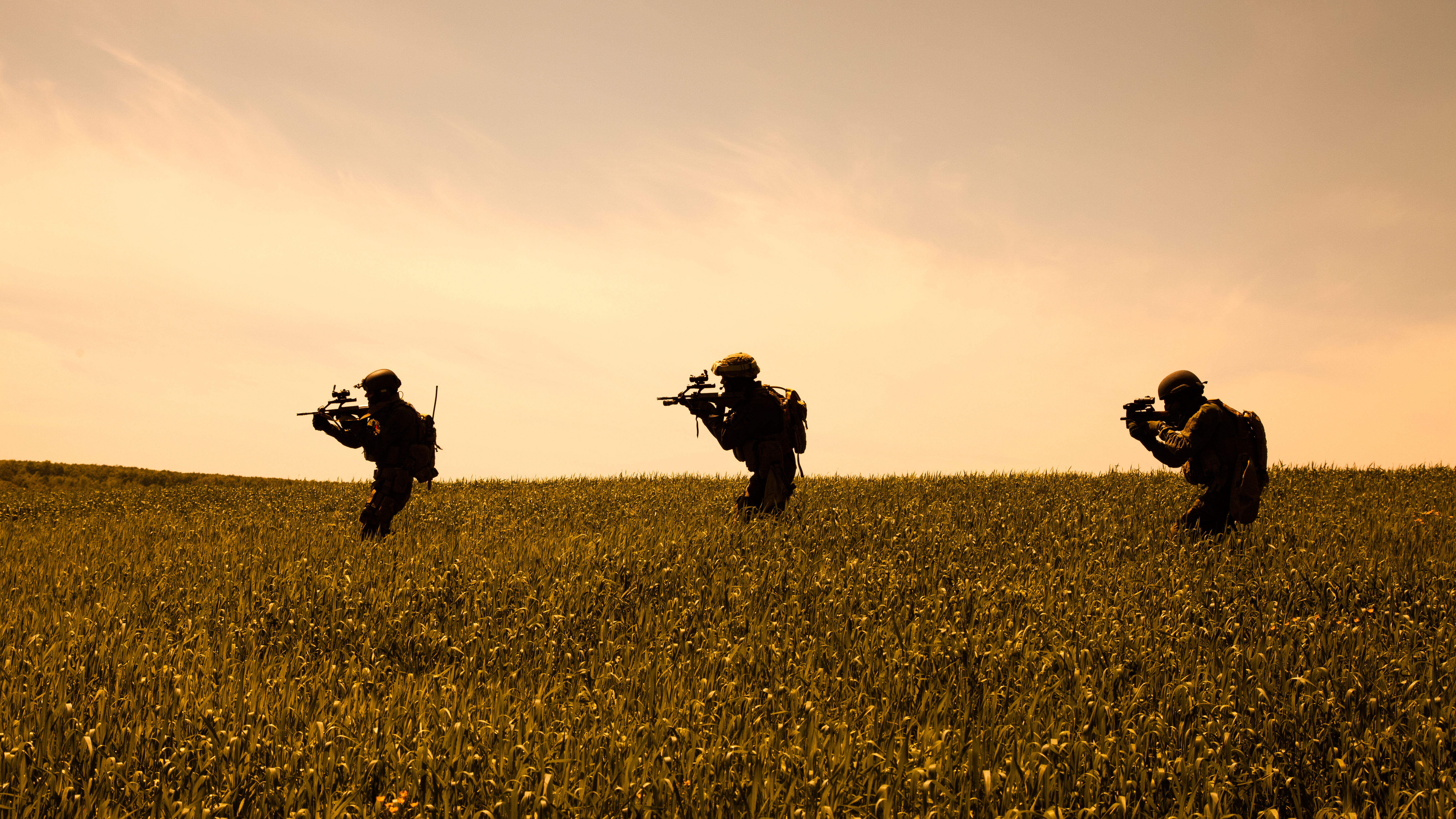 Drei Soldaten bei einer Übung im Gras