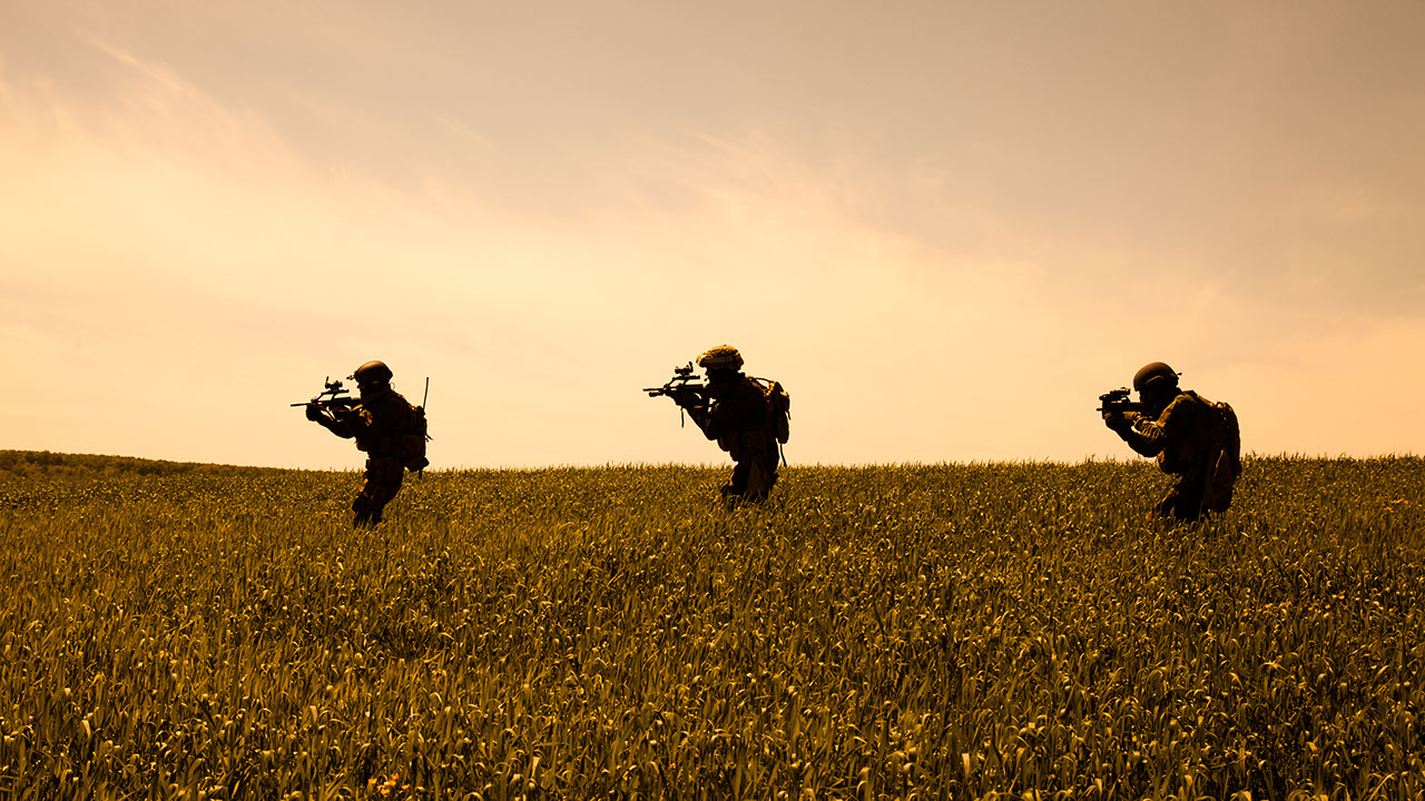 Drei Soldaten bei einer Übung im Gras