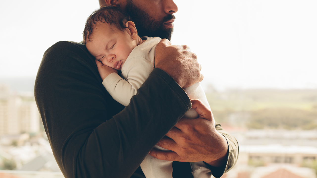 Mann hält Baby fest im Arm