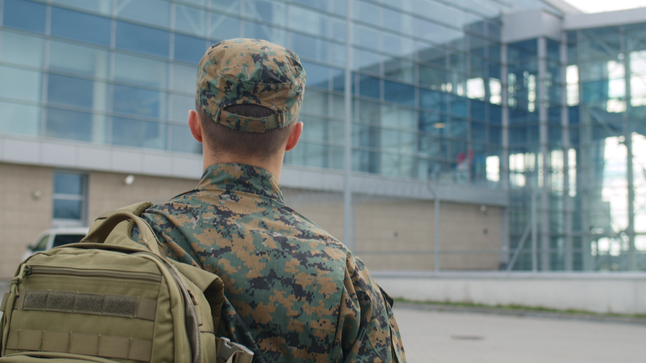 Soldaten von hinten mit einem Gebäude im Hintergrund